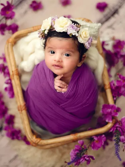 Sometimes a newborn is calm and awake, and their curious eyes make for a stunning portrait. The floral crown and purple tones complement her beautiful gaze.