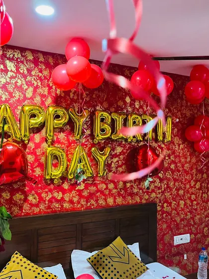 This birthday surprise was set against a vibrant red and gold wallpaper. We used gold foil "HAPPY BIRTHDAY" balloons and red latex balloons to complement the room's existing decor.