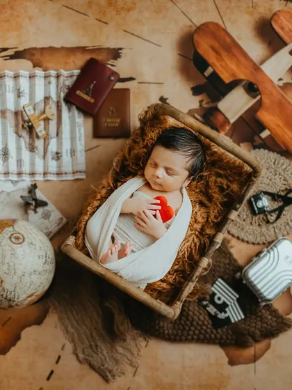 A newborn version of the tiny traveler theme, showing that the adventure can start from day one.