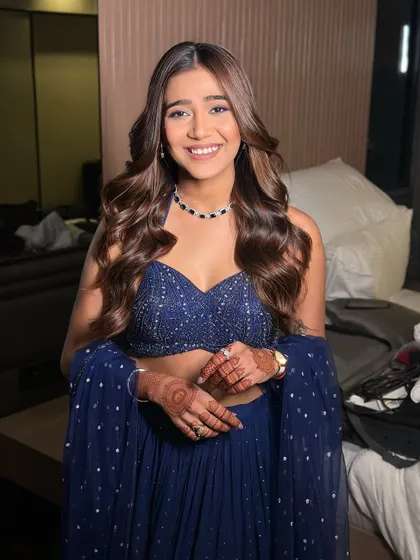 The complete look, showing the beautiful flow of her hair and the elegant simplicity of her navy blue outfit. It's a chic and modern choice.