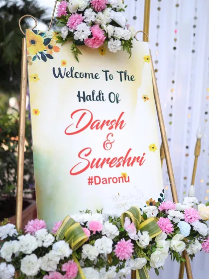 A beautiful, custom welcome sign for Darsh and Sureshi's Haldi ceremony. The watercolor design and floral arrangements create an elegant and personal welcome for all the guests.