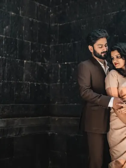 A dramatic and intimate portrait against a dark, textured wall. This kind of lighting and posing creates a sophisticated and modern pre-wedding look.