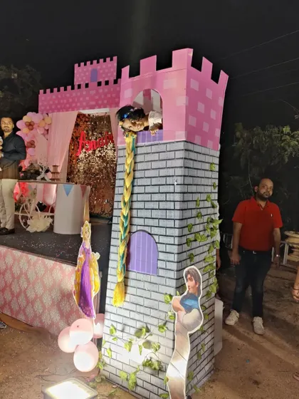 A guest posing in the Rapunzel tower, showing the interactive nature of the life-sized prop.