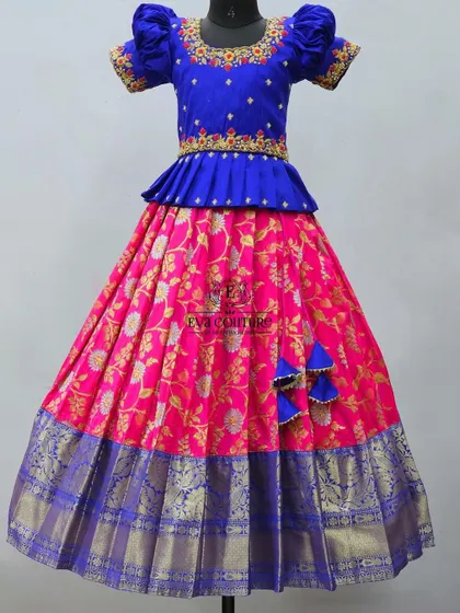 A vibrant pattu pavadai in royal blue and pink. The blue blouse has a beautifully embroidered neckline and puff sleeves.