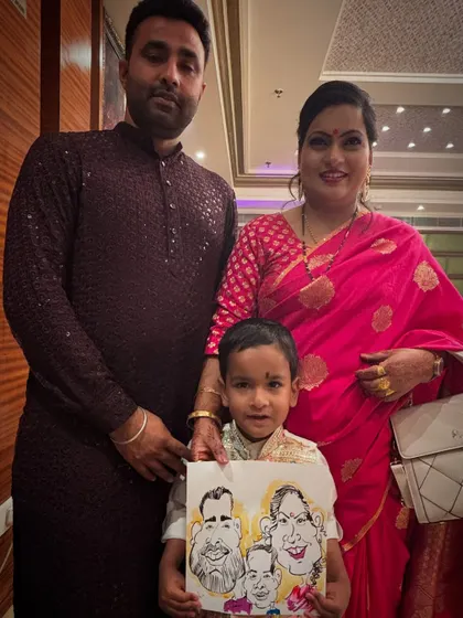 A beautiful family portrait, with the little one holding their special caricature.