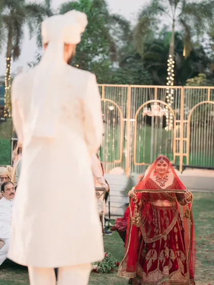 The first look from the groom's perspective. A moment filled with anticipation and love as the bride makes her way to the mandap.