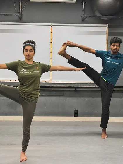 Our trainers demonstrate an advanced standing yoga pose, showcasing the balance, flexibility, and strength that we help our members cultivate in our yoga and mobility classes.