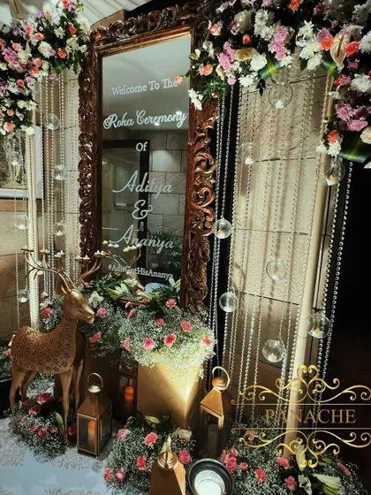 A personalized welcome mirror for the Roka ceremony, framed with lush florals and whimsical elements like a golden deer. This creates a beautiful and personalized photo spot for the couple and guests.