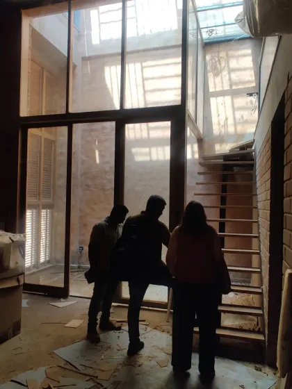 My team and I on site, discussing details in a space with large glass panels and a skylight under construction.