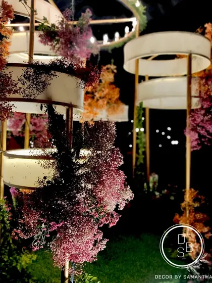 A detailed shot of the custom light installation at the reception. The tiered design, wrapped in fabric and florals, created a stunning focal point as night fell.