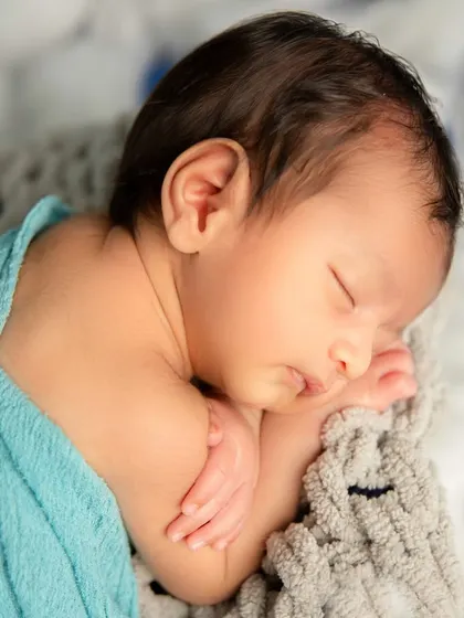 Lost in a world of dreams. This close-up captures the peaceful profile of a sleeping baby, from his dark hair to his perfectly formed ear.