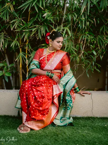 A quiet moment for the bride, Ankita, seated against a bamboo backdrop, looking contemplative and beautiful.