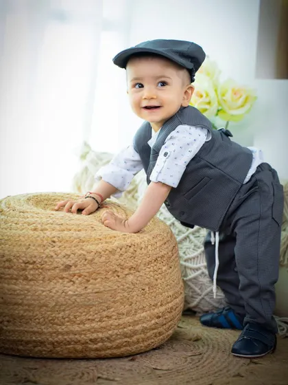 A dapper little gentleman trying to stand. The simple jute pouf is a great prop for babies who are just finding their feet.