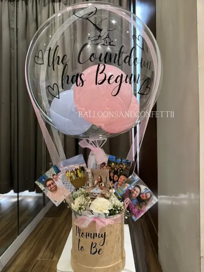 A closer look at the "Mommy to Be" hamper, showing the personalized balloon and the arrangement of photos and flowers. It's all about the little details.