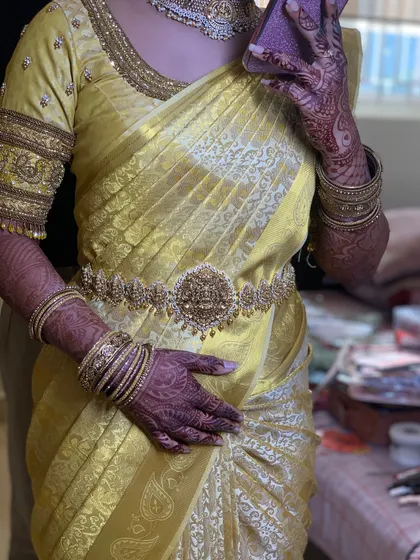 This bride is glowing in her golden yellow Muhurtham saree. The drape is kept classic and neat to let the saree's colour and the temple jewellery shine.