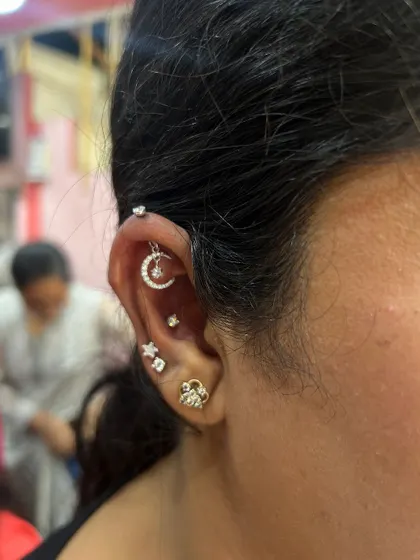 A celestial-themed ear stack with a crescent moon and star hanging, perfect for those who love a dreamy, whimsical style.