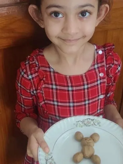 This girl's sweet smile reflects her pride in her creation. Making food in a fun shape adds an element of play and artistry to the practical life skill of cooking.