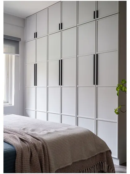 For a minimalist aesthetic, we designed these floor-to-ceiling wardrobes with clean geometric lines and long, black handles. The simple design maximizes storage while keeping the room feeling calm and uncluttered.