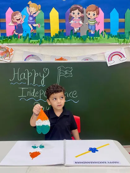 Holding up his finished piece, this student displays his tricolor leaf print. Our art sessions are designed to give children a sense of accomplishment and pride in their work.