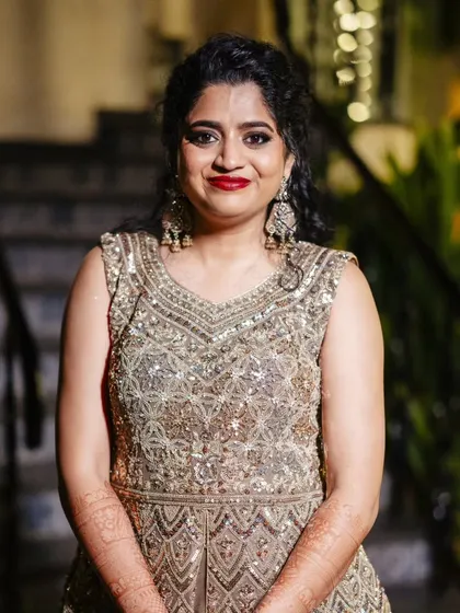 A close-up of her sangeet look. The smokey eye makes her eyes pop, and the red lip adds a perfect touch of bridal glamour.