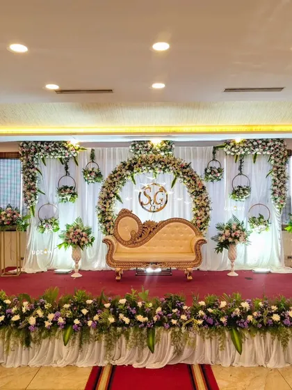 A lovely engagement stage with a floral arch and hanging floral hoops.