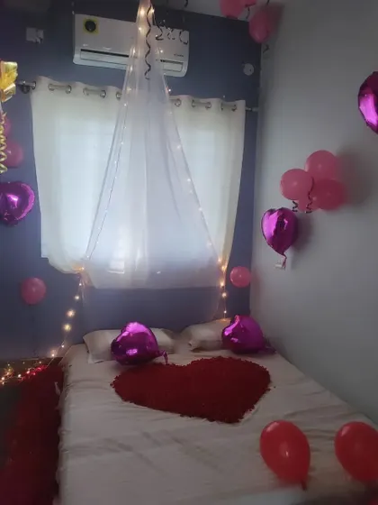 A simple and romantic first-night bedroom decoration. I used a canopy with fairy lights, heart-shaped balloons, and rose petals on the bed to create a special ambiance.