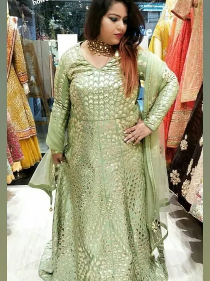 A client models a lovely pistachio green Anarkali with intricate gold foil work. This is another example of the variety you can find when you visit the store.