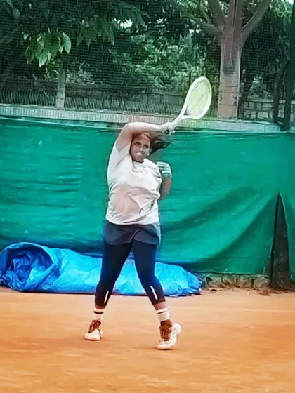 A female player unleashes a powerful overhead shot during the Tennis360 TS7 AITA U-14 tournament.