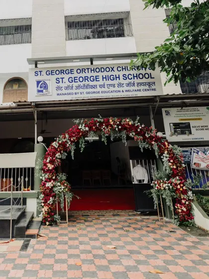 The entrance to St. George Orthodox Church, adorned with a lush floral arch of deep reds and whites. This created a grand and passionate welcome for the wedding guests.