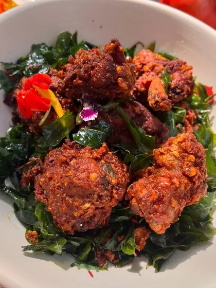 A close-up of our special Christmas chicken fry, served on a bed of crispy curry leaves. The fiery masala coating and tender chicken make this dish impossible to resist.