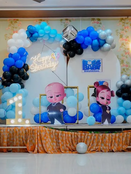 A closer look at the Boss Baby stage decoration, showing the detailed character cutouts and balloon arrangement. The 'Happy Birthday' neon sign adds a modern touch to this popular kids' birthday party theme.