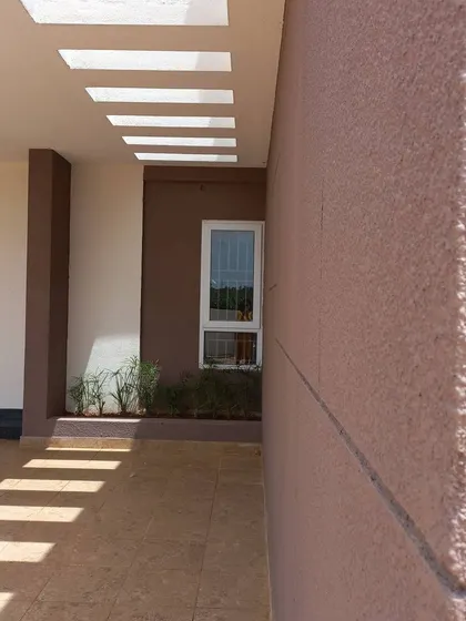 Another perspective on the play of light, emphasizing the texture of the exterior wall and the clean, modern window frame.