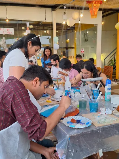 A group of artists at a beach painting workshop. I'm here to provide guidance and support to help everyone create their masterpiece.
