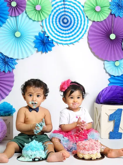 A colorful twin cake smash session. Each baby has their own cake, and their expressions are priceless as they dig in for the first time.