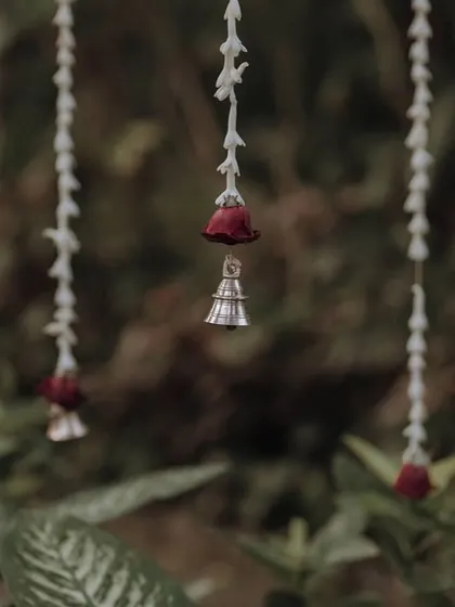 Delicate hanging strings of jasmine and rosebuds with tiny bells, a small detail that adds immense charm and a gentle sound to the decor.