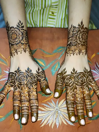 A beautiful anniversary henna design featuring elegant rose patterns on the hands and wrists.