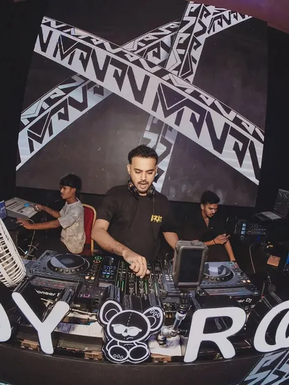 At the console at Toy Room Pune, surrounded by the club's signature branding. My focus is on crafting the perfect melody progression.