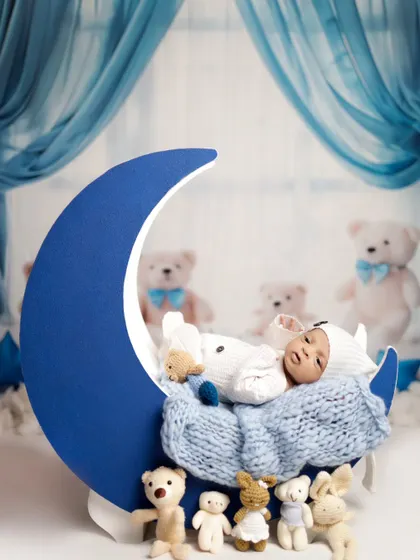 Another angle of our moon prop, this time with the baby awake and looking around. We work at the baby's pace, capturing both sleepy and alert moments.