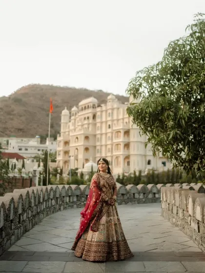 A bride standing against the majestic backdrop of the Raajsa Resort, looking like a queen in her own palace. I help select locations that enhance the royal feel.