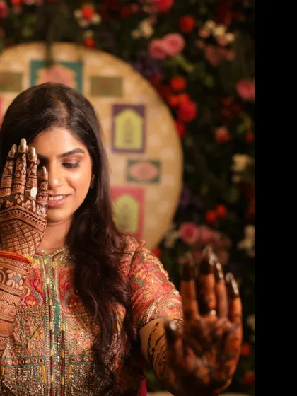 A creative pose showing off the beautiful, dark stain of the bridal mehandi. The intricate design on the palm is the highlight of this shot.