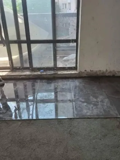 Work in progress at Unitech Cascades. This image shows our team carefully laying large-format, glossy floor tiles to create a seamless and modern look.