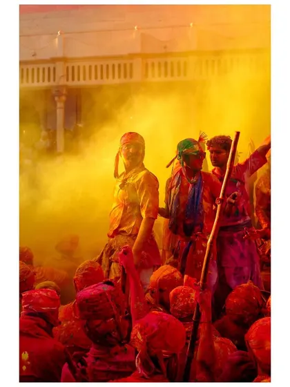 A man stands amidst a cloud of yellow powder, a central figure in the vibrant chaos of Holi. This image captures the feeling of being at the heart of the celebration.