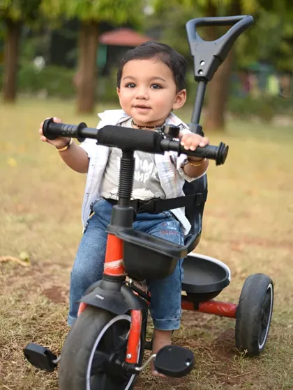 Another great shot of the one-year-old on his tricycle, looking right at the camera.