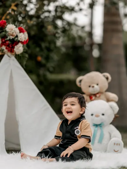 A big, happy laugh is the best thing to capture. This little boy's joyful expression during his outdoor birthday shoot with a teepee and teddy bears is a perfect example of a genuine, happy moment.