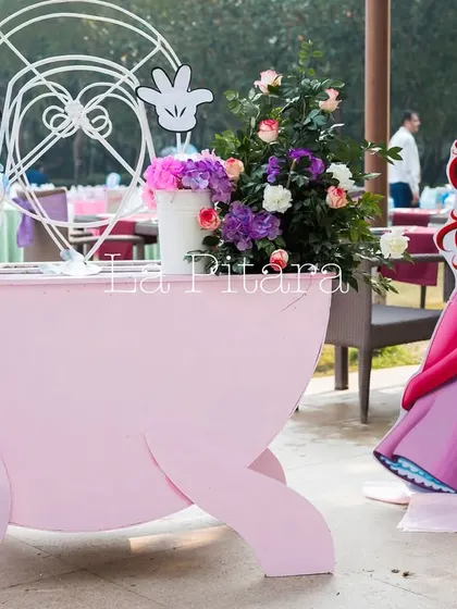 A charming pink cart with a Ferris wheel detail, accompanied by a cutout of Princess Ariel.