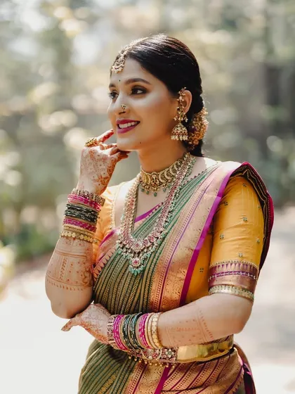 A close-up, side-profile shot, capturing her joyful expression and the intricate details of her makeup and jewellery.