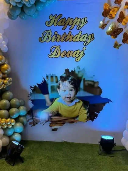 A personalized birthday backdrop featuring a photo of the birthday boy, framed by an elegant balloon garland.