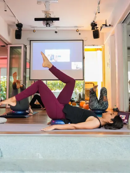 A hybrid class in session, with students both in the studio and joining online via the projector. Movement makes us better human beings, no matter where we are.