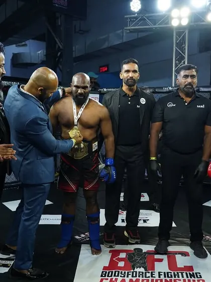 Receiving the gold medal inside the cage. This moment represents the peak of a fighter's journey, and it's what we train our athletes to achieve.