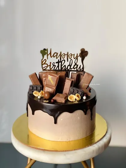 Another look at my Chocolate Overload cake, this time with a smooth chocolate frosting base. The dark chocolate drip and variety of toppings make it irresistible.